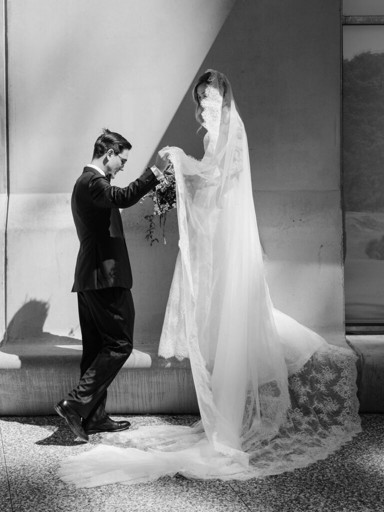 Groom presenting bride with dark trailing calla lily bouquet inside the Bundanon art gallery – black and white wedding portrait, Southern Highlands